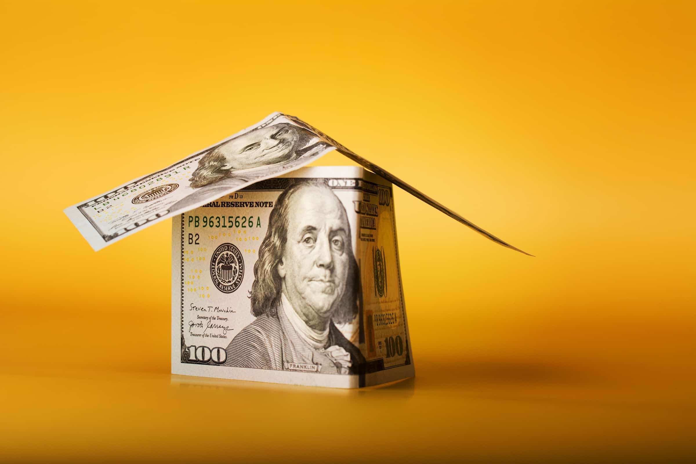 Hundred Dollar Bills Folded Into A House Shape